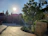 Charming hotel courtyard with stone walls and lush greenery under soft sunlight.