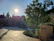 Charming hotel courtyard with stone walls and lush greenery under soft sunlight.