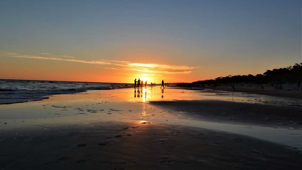 a beach with people walking on it