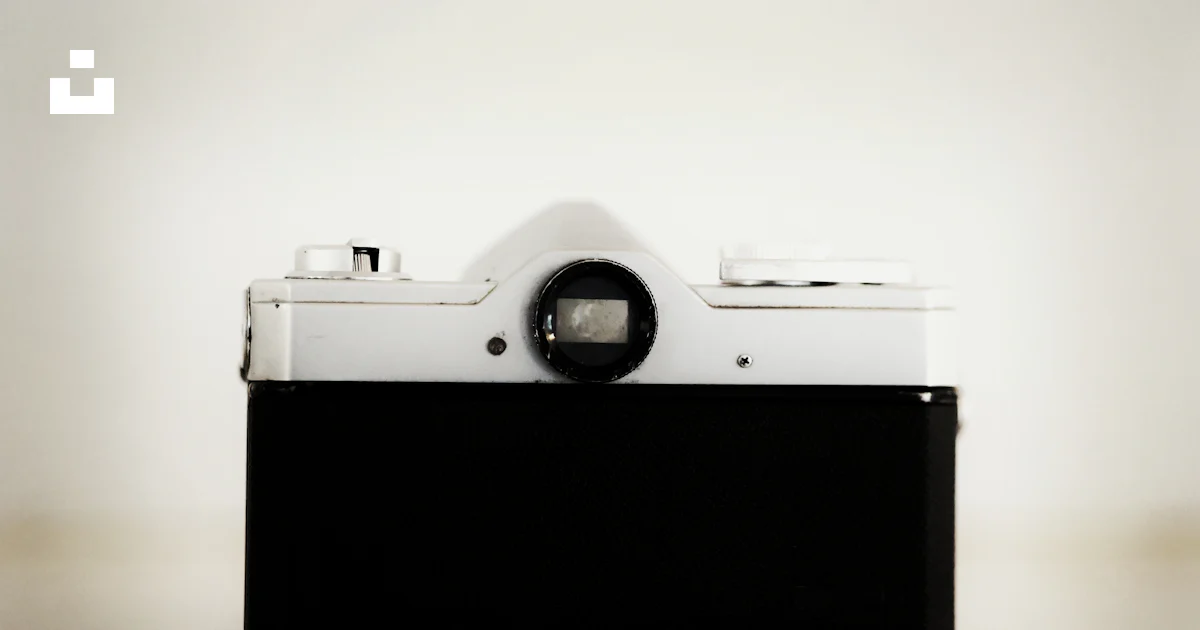 A black rectangular object with a round lens on a white surface photo ...