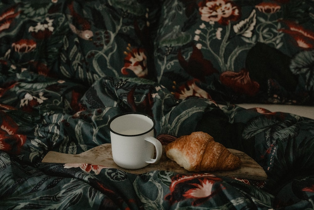a cup of coffee on a floral blanket
