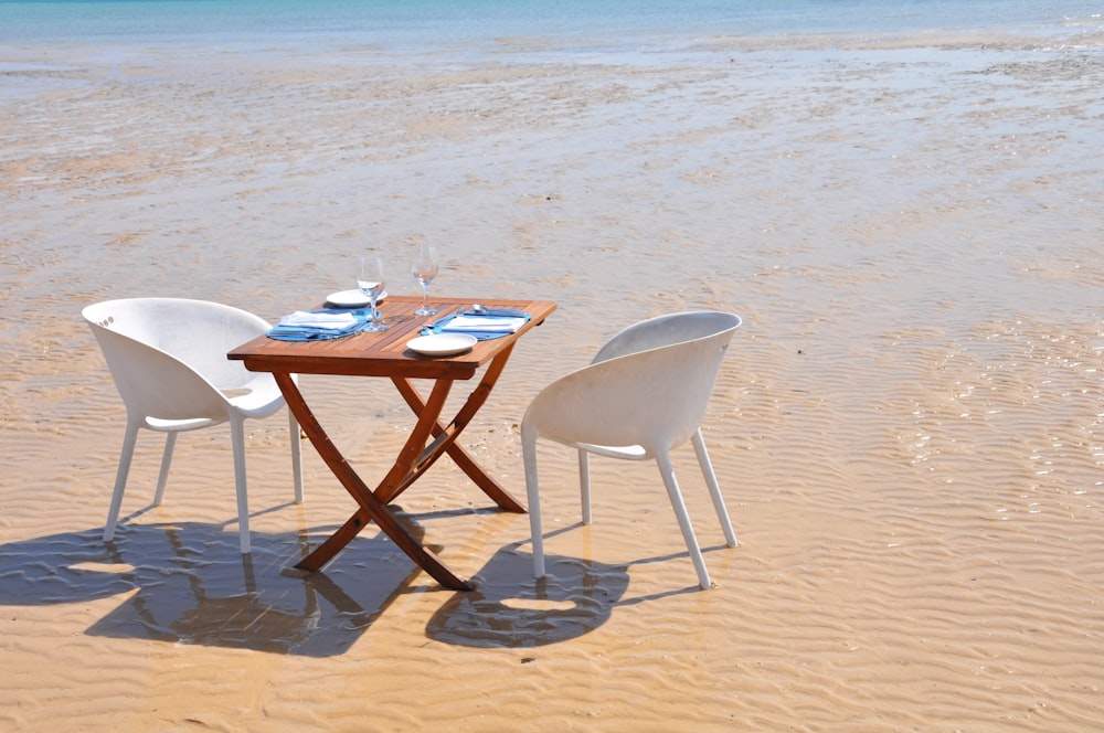 a table and chairs on a beach