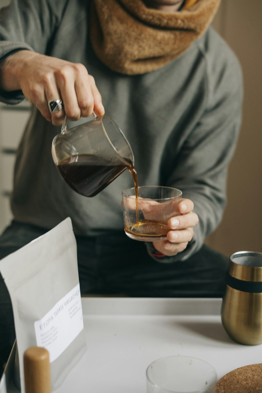 a person pouring a drink into a glass