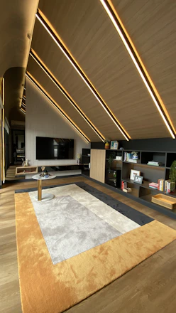 A sleek living room showcasing integrated smart lighting and elegant surface finishes.