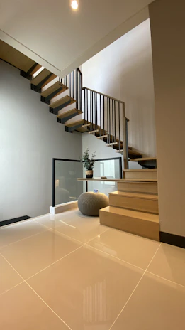 Bright, modern living room featuring elegant wooden stairs crafted by medžioaura.