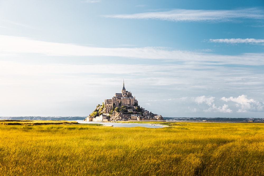 a castle on a hill with Mont Saint-Michel in the background