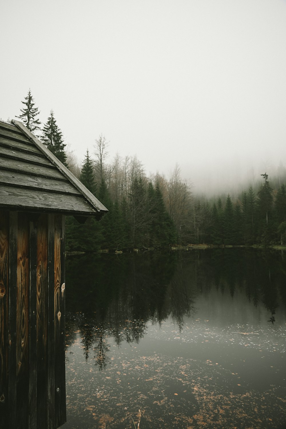 a wooden building next to a lake