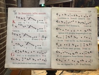 Close-up of sheet music with Gregorian chant notation on an altar.