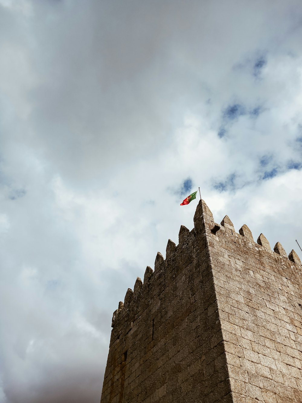 a stone building with flags on it