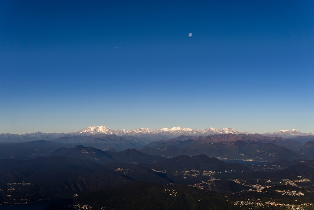 a mountain range with the moon in the sky