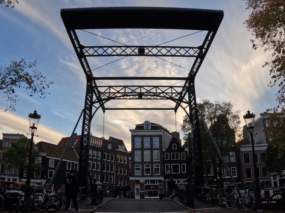 a large metal structure with a group of people walking around