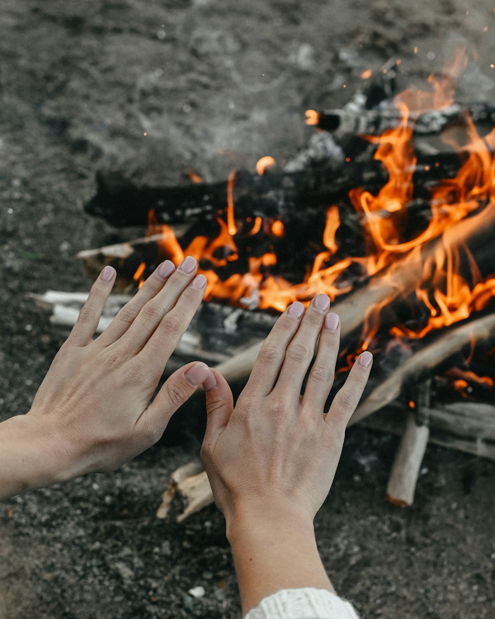 mãos segurando um cigarro sobre um fogo