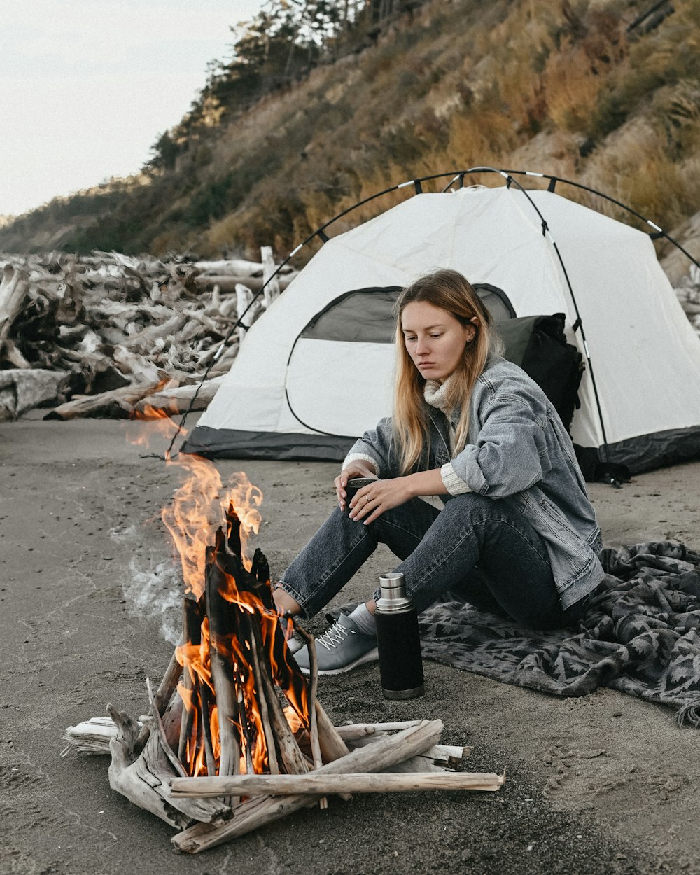 a person sitting next to a campfire