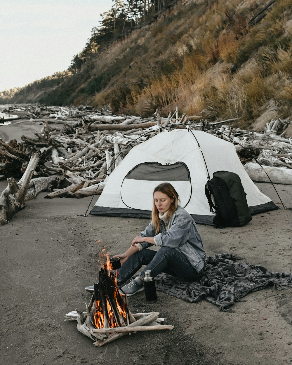 a person sitting next to a tent