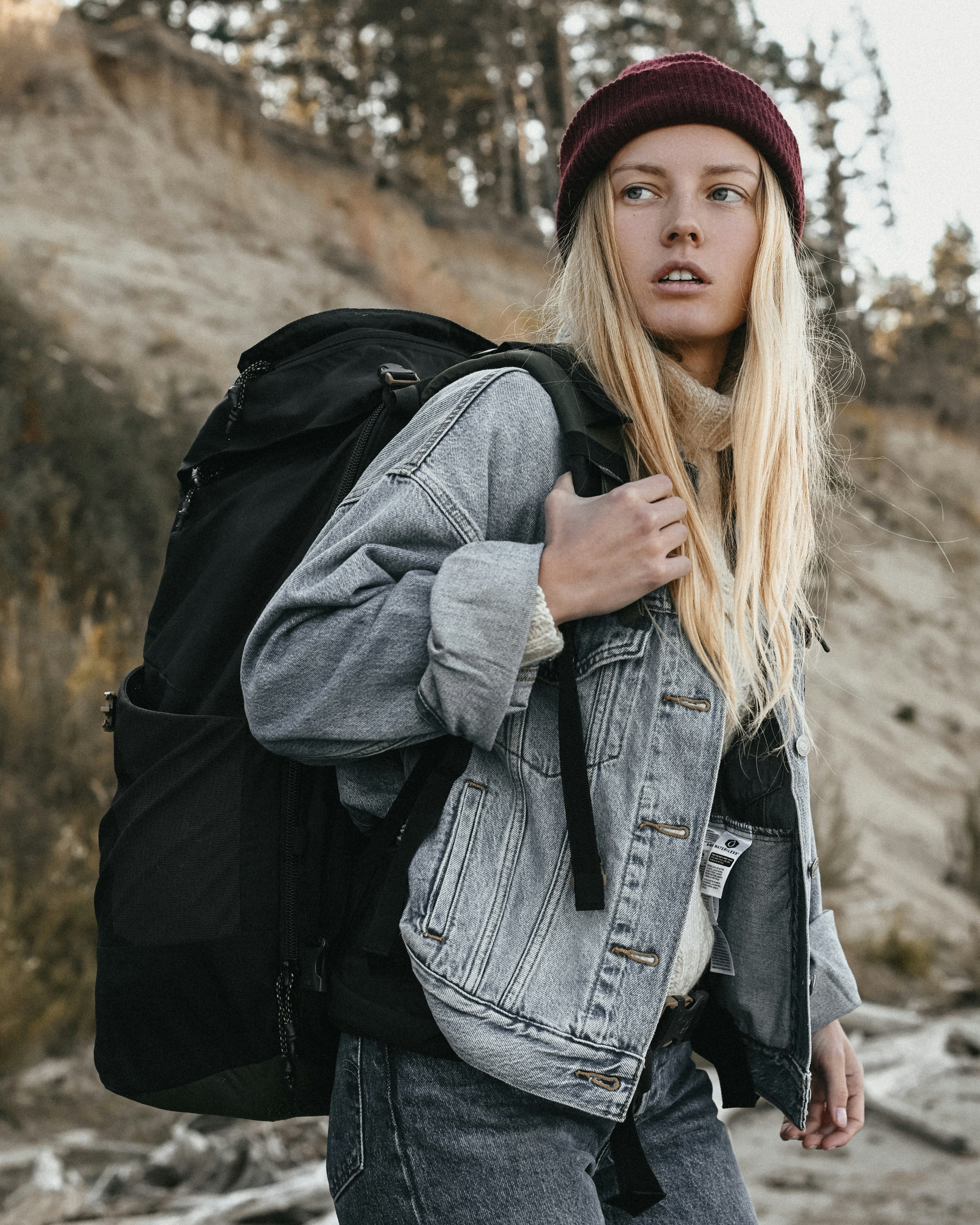 a woman with long hair and a backpack