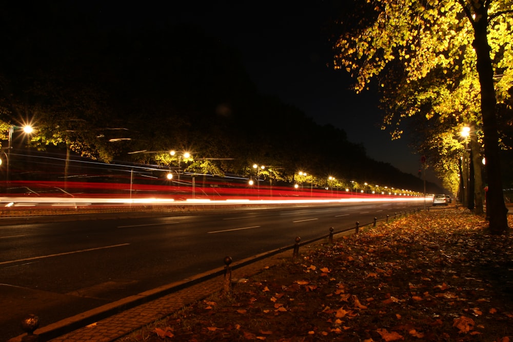 a road with cars on it and trees on the side