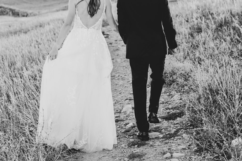 a man and woman walking down a dirt path