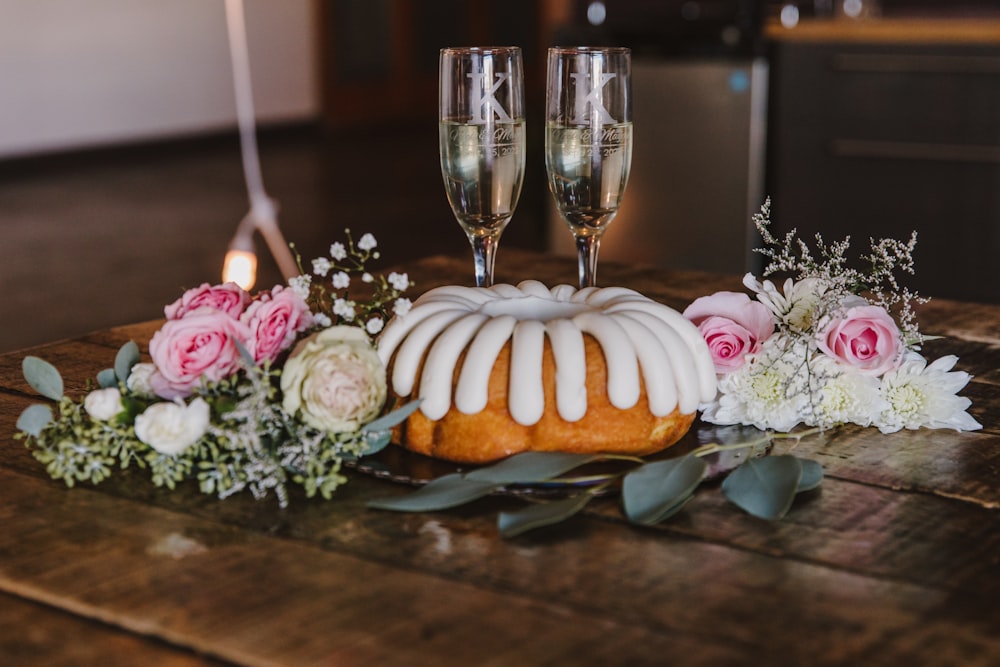 a cake with white frosting and flowers on a table