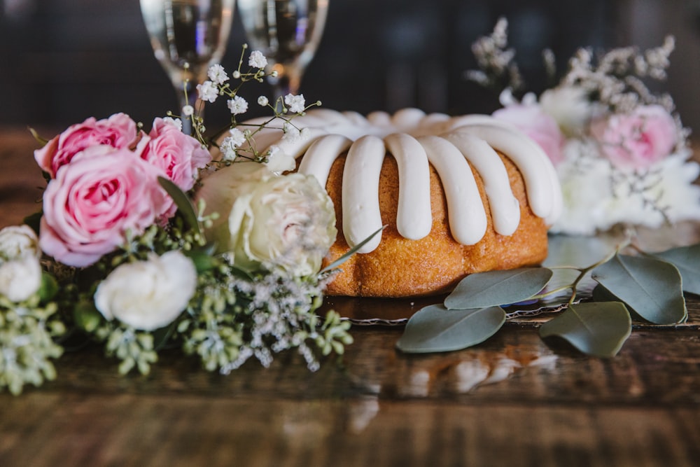 a cake with white frosting and flowers on a table