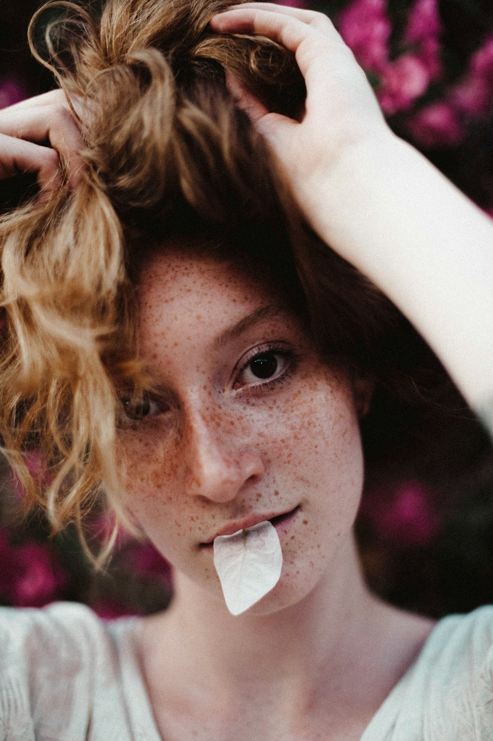 a person with a white shirt and a white shirt holding a piece of food to the mouth