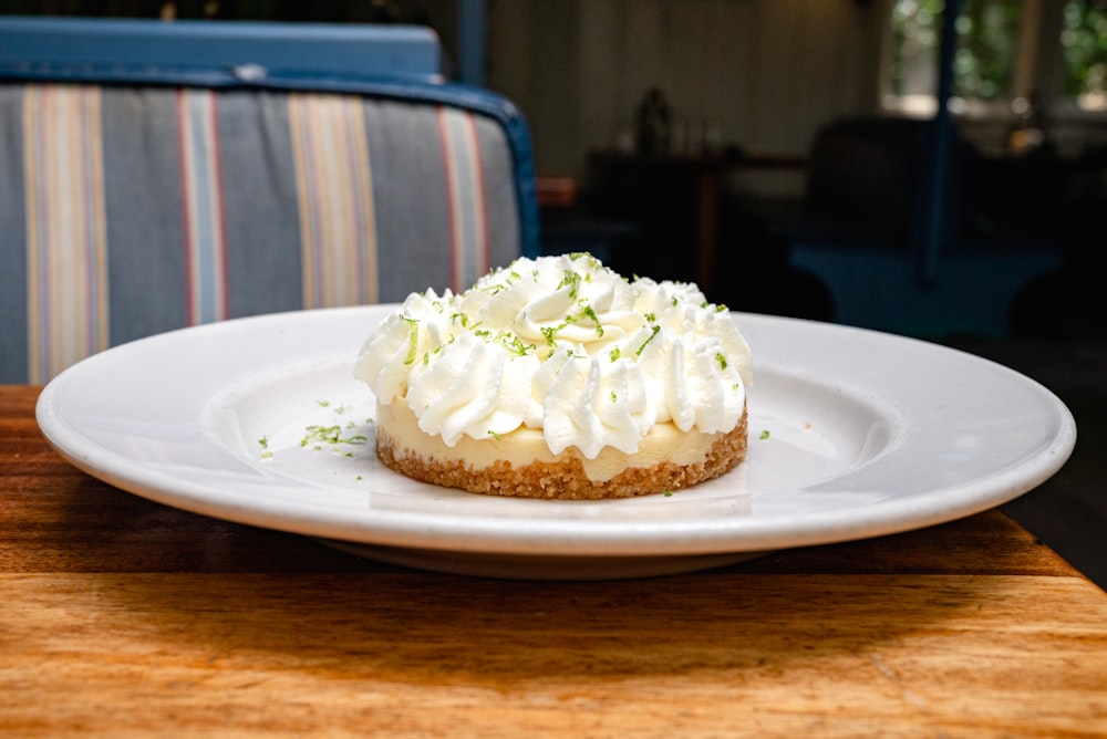 a cupcake with white frosting on a plate