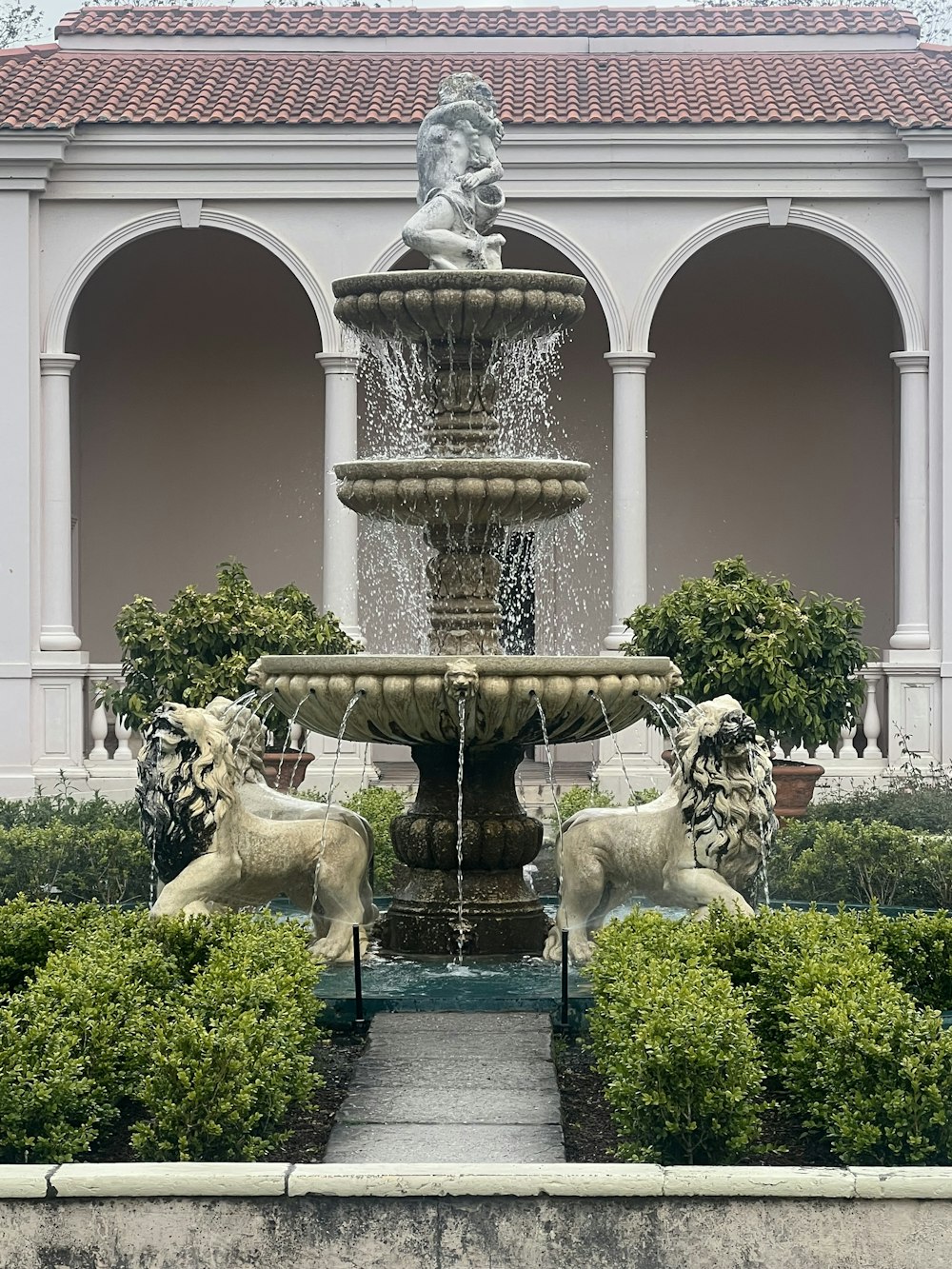 a fountain with statues in front of a building