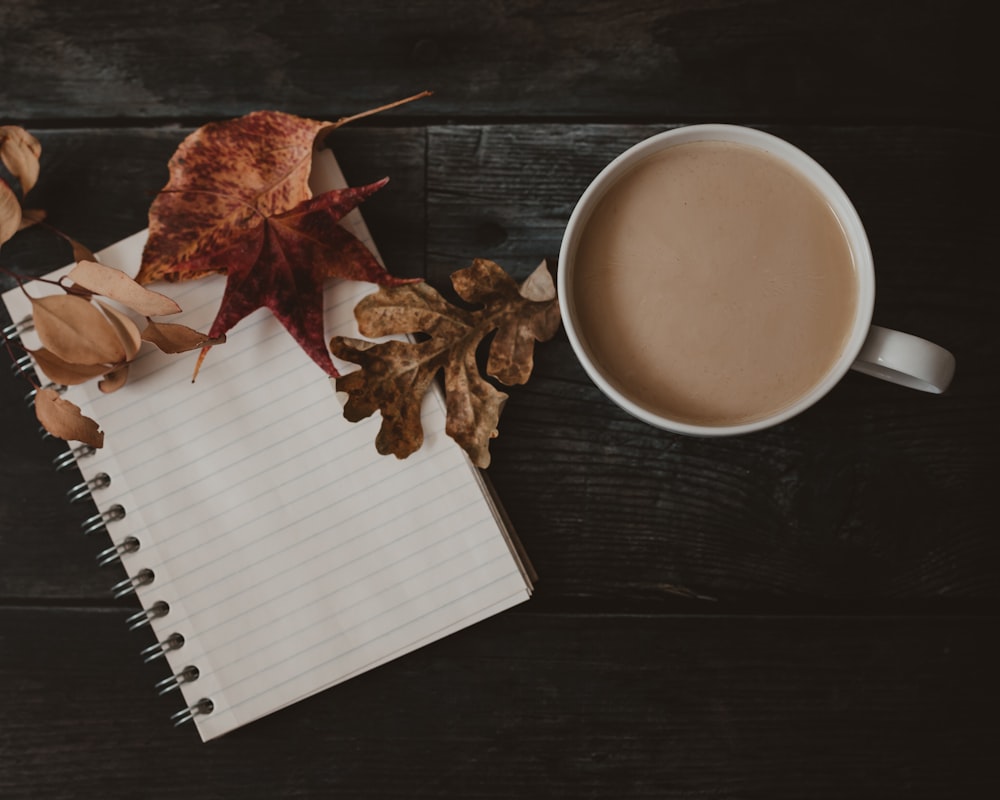 a cup of coffee and leaves on a table