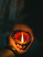 a hand holding a lit candle