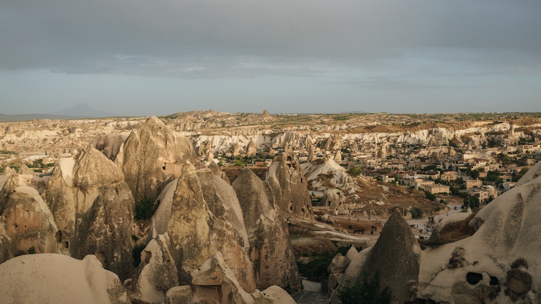 a rocky canyon with a town in the distance,