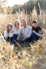 a group of people sitting in a grassy area