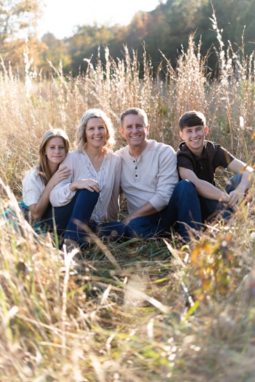 a group of people sitting in a grassy area
