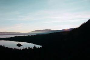 A tranquil alpine lake reflecting the surrounding peaks at sunset