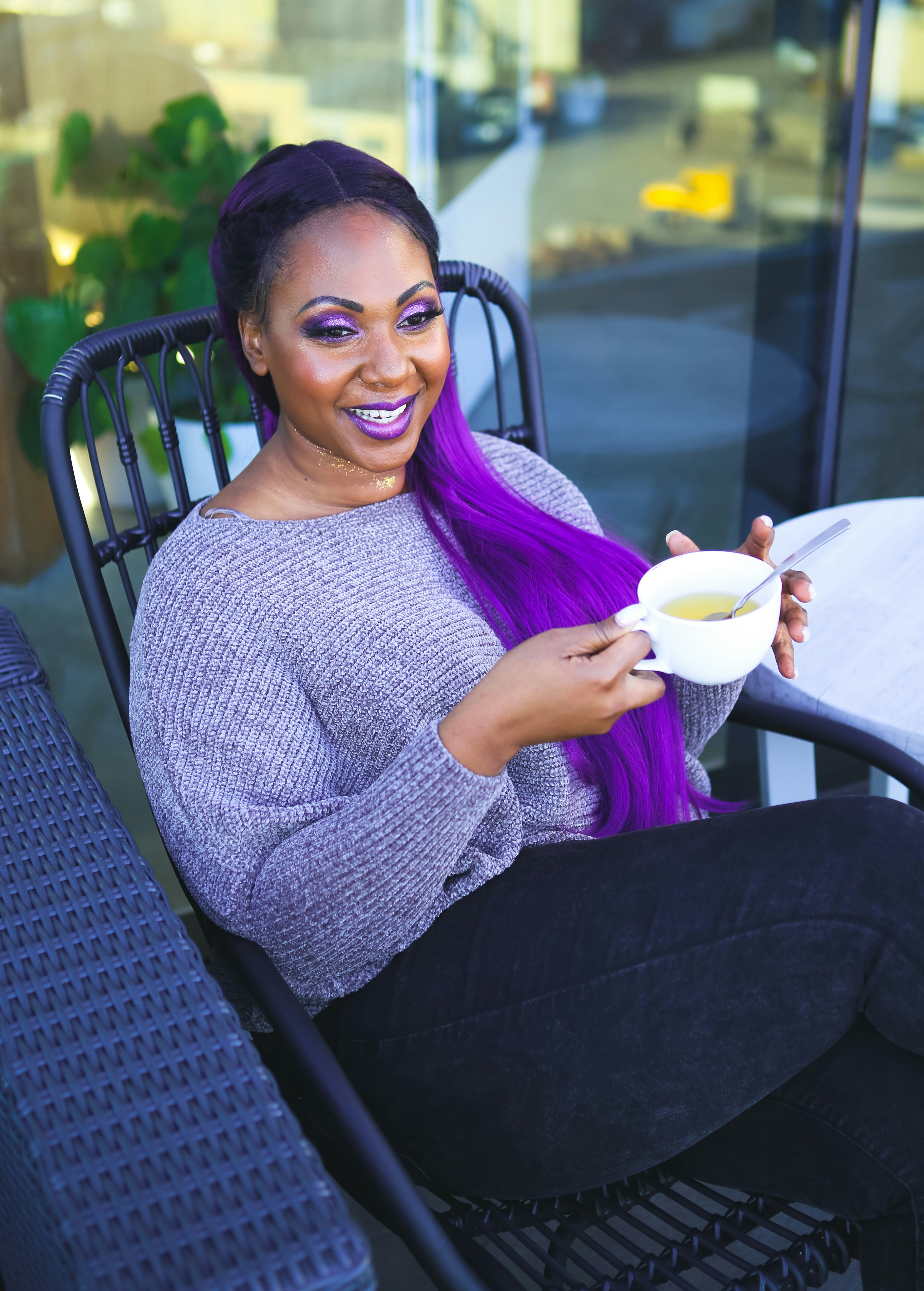 a woman sitting at a table holding a cup of coffee