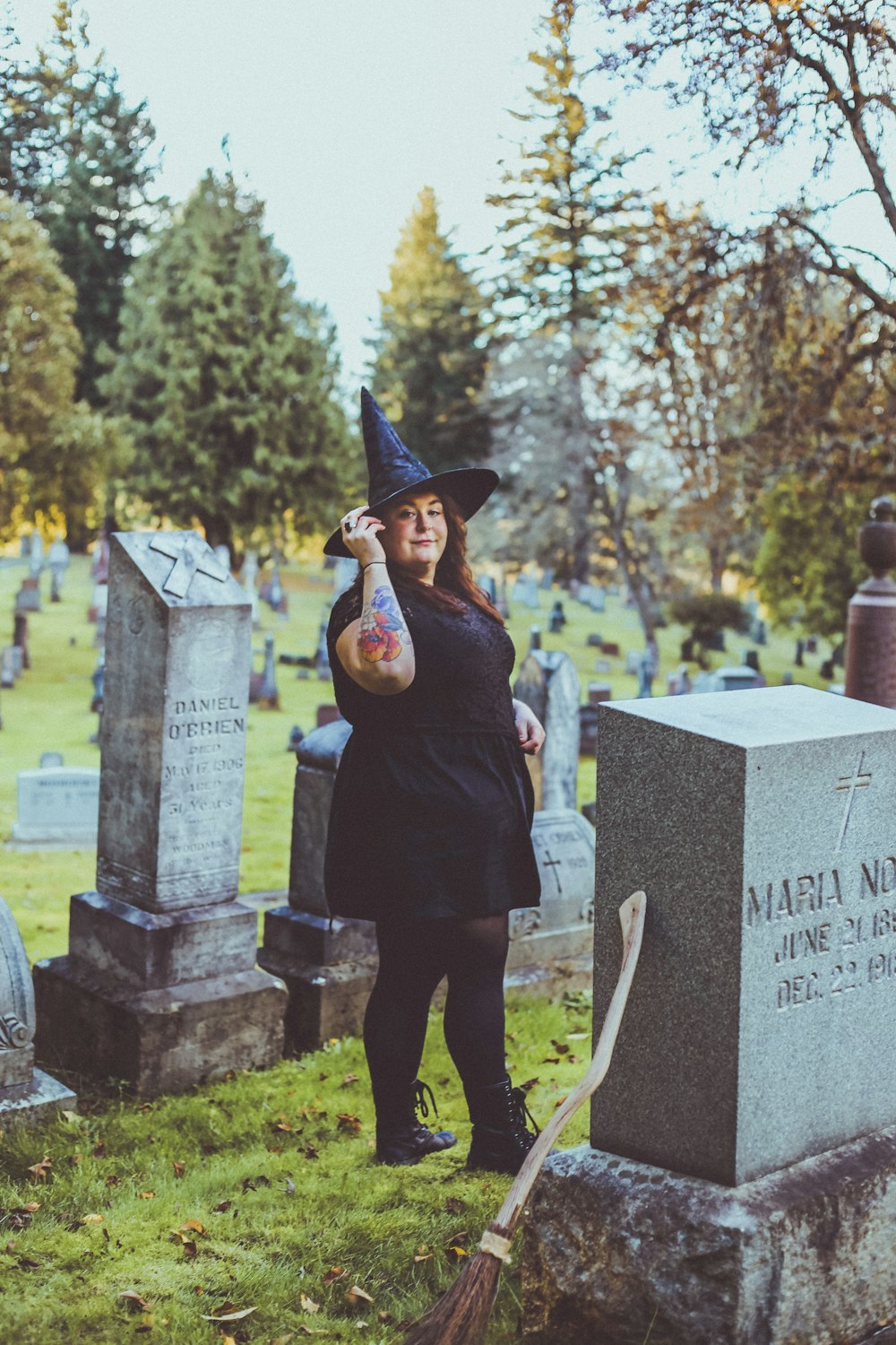 a person in a graduation cap and gown standing in a cemetery