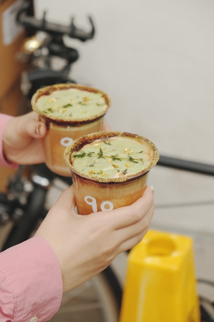 Close-up of hands on the handlebars with colorful drinks resting on the trolley’s built-in cup holders