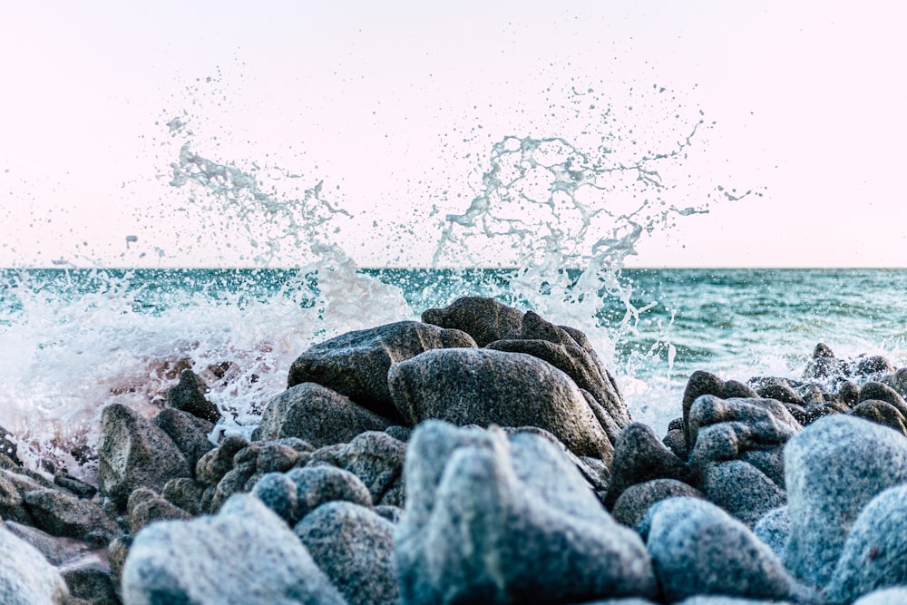 a rocky beach with water and a cloudy sky