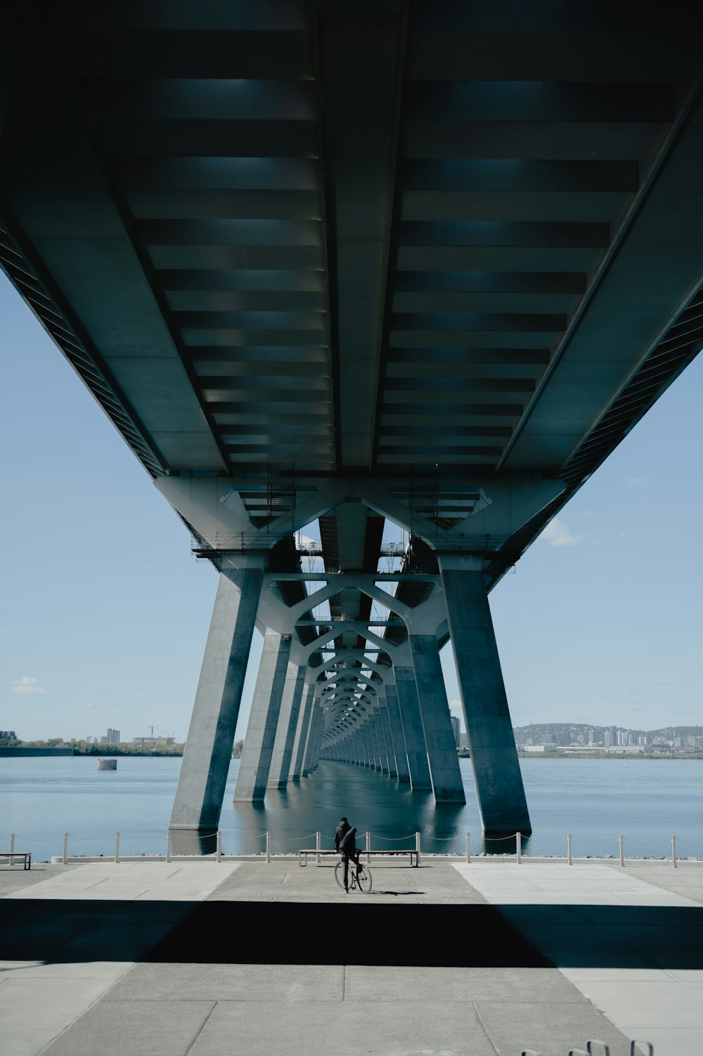 a person riding a bicycle under a bridge