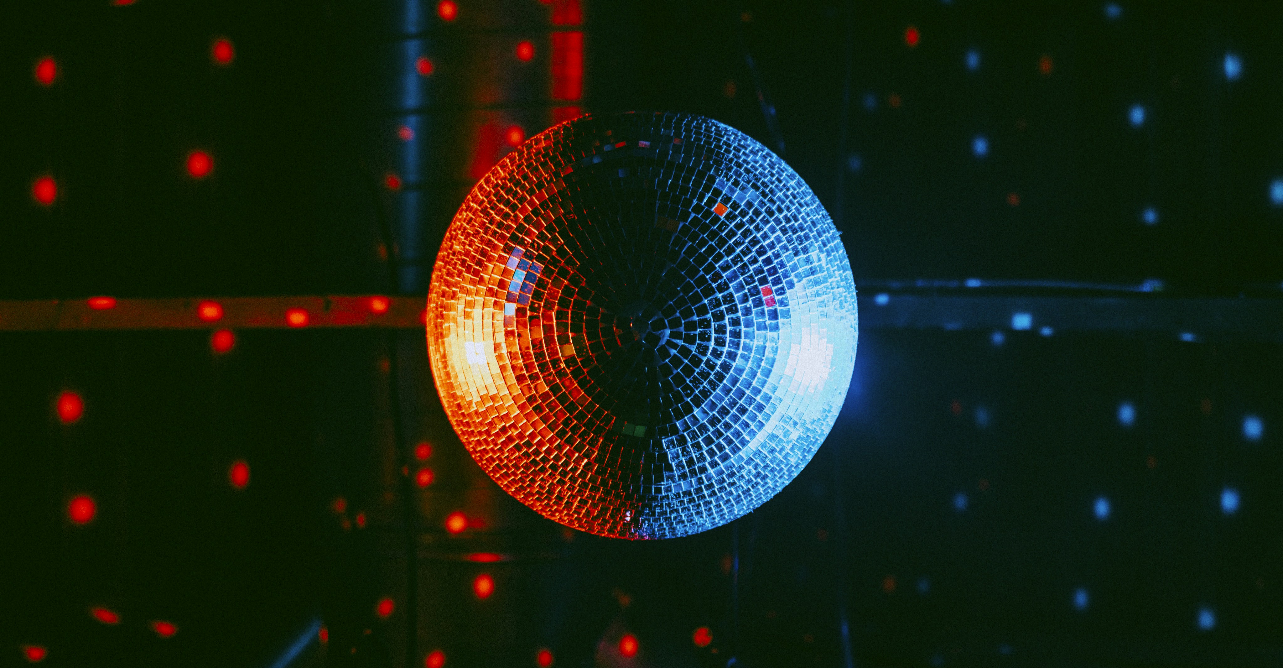 a red and blue circle with white dots and a black background