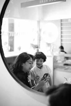 Happy family reviewing live security footage on a smartphone indoors.