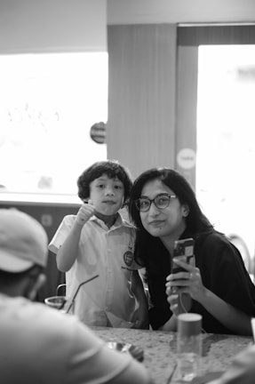 A happy parent and child discussing lesson plans with a yteach tutor via WhatsApp on a smartphone.