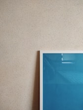 Close-up of a delicate digital artwork with subtle textures and muted neutral tones displayed on a clean white wall.