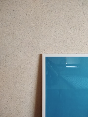 Close-up of a vibrant digital art print hanging on a minimalist white wall.