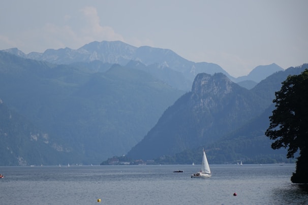 A serene lakeside view with a small wooden boat gently floating on calm water.