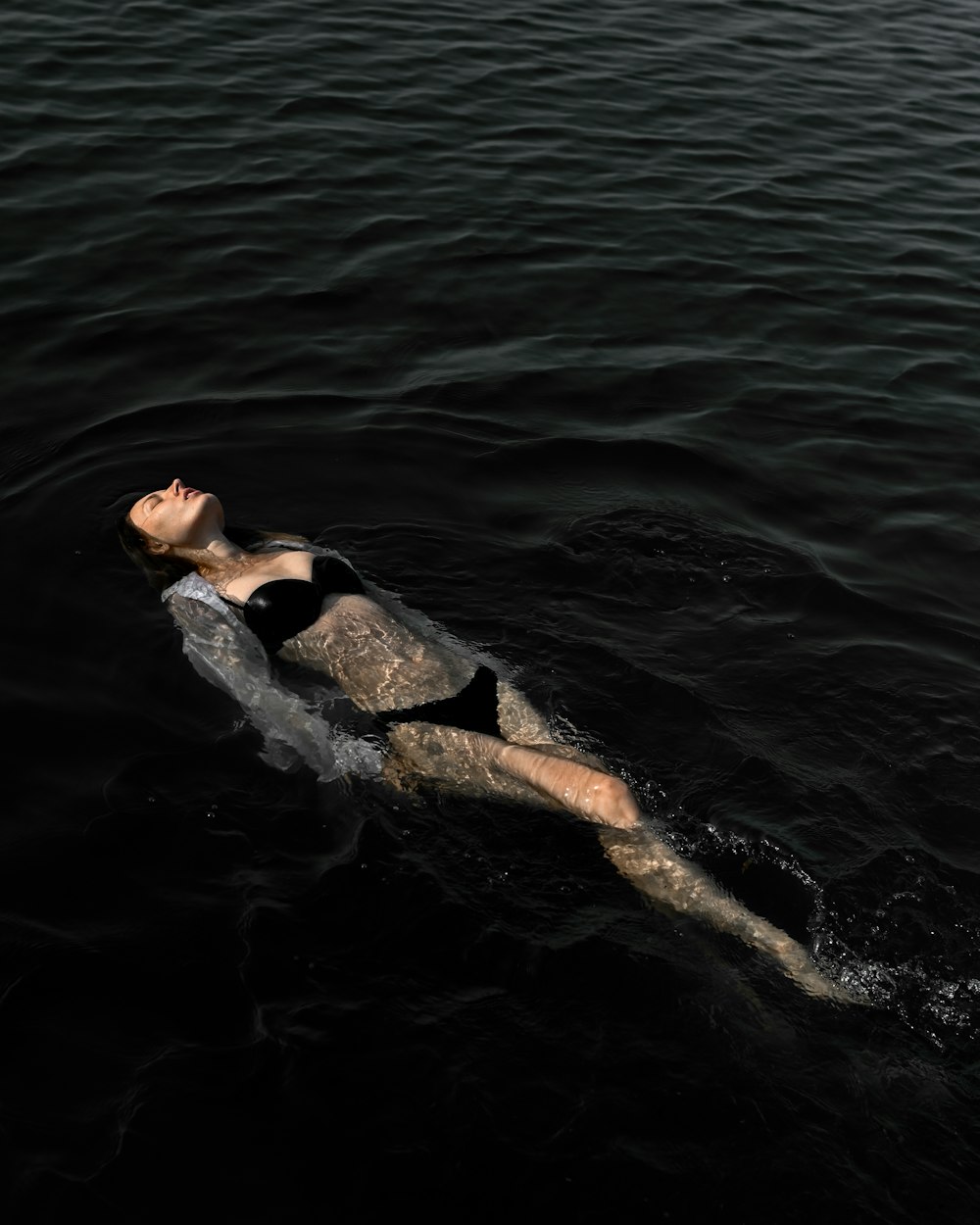 a person lying on a whale's back in the water