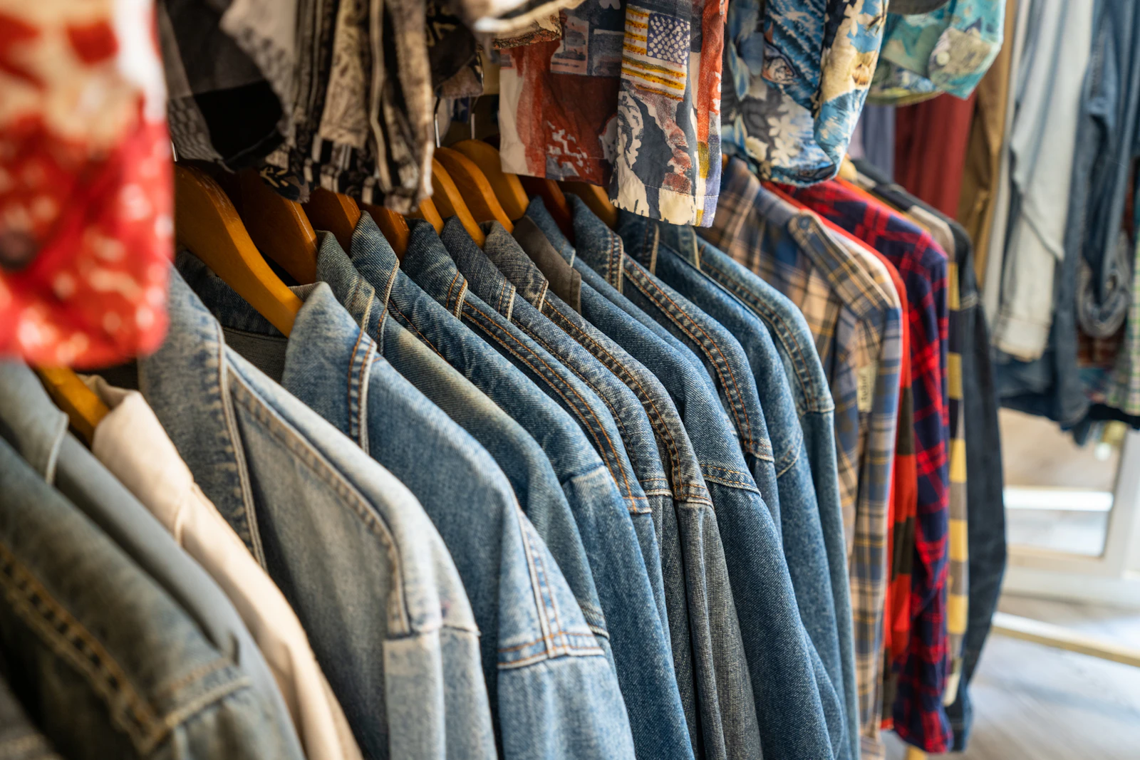 Rail of vintage denim jackets and retro shirts
