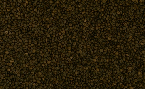 A dense and textured surface covered entirely with roasted coffee beans. The beans are variably sized and colored, ranging from medium to dark brown.