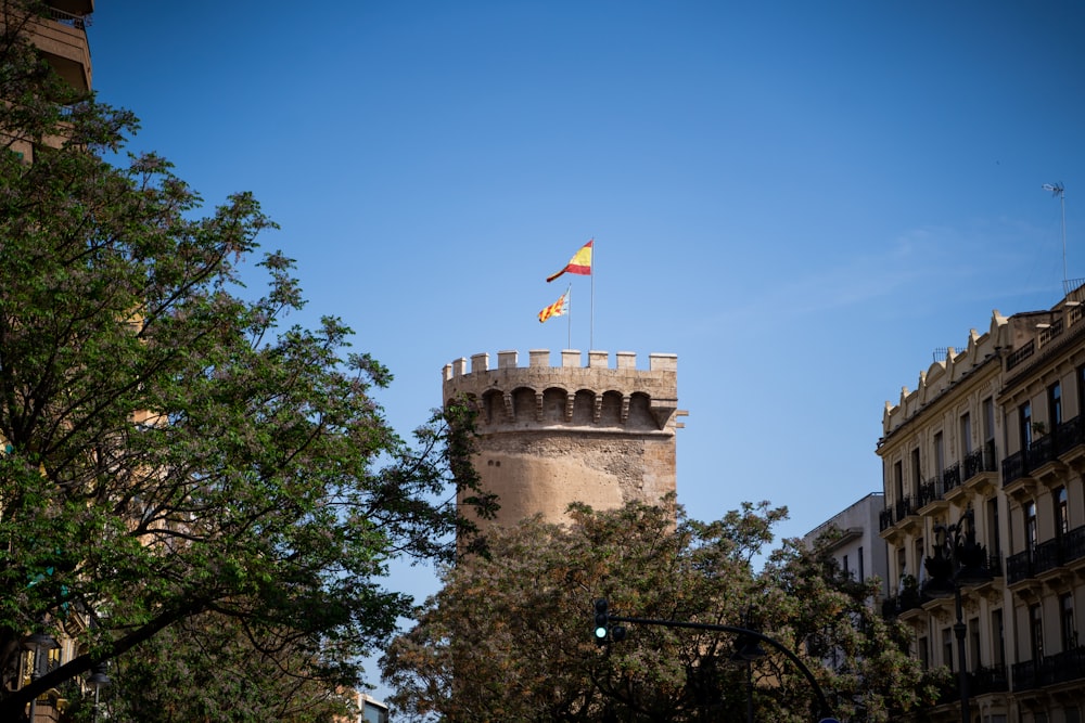 a stone tower with flags on it