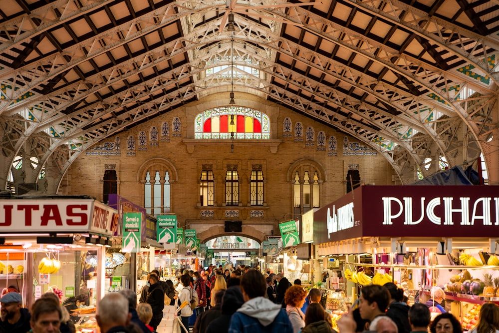 a crowd of people in a large building with signs