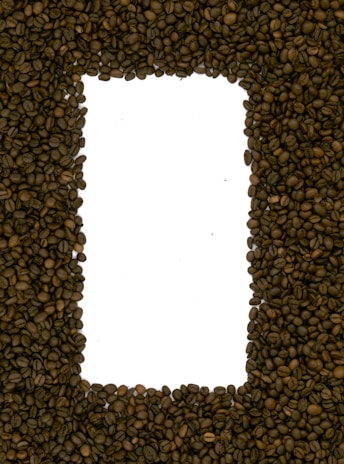 A rectangular frame made from dark brown coffee beans, with a white background visible in the center.
