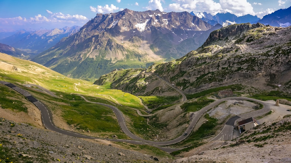 a winding road through a valley between mountains